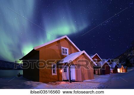 Stock Image - "Aurora over fishing huts, Tromso, â€ªTroms, Northern Norway, Norway, Europe". Fotosearch