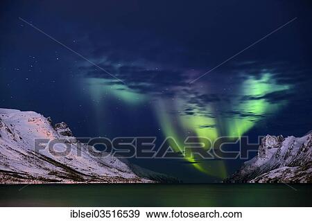 Stock Photo - "Aurora over fjord with snowy mountains, Ersfjord, Tromso, â€ªTroms, Northern Norway, Norway, Europe". Fotosearch