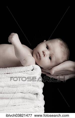 Stock Photo - Baby lying on a pile of towels. Fotosearch