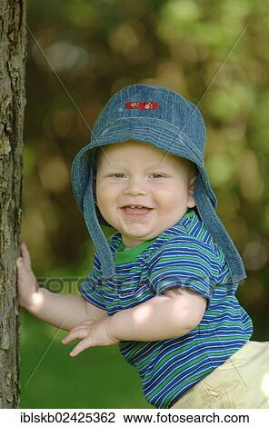 "Baby, one year, standing by a tree" View Large Photo Image Stock Image - "Baby, one year, standing by a tree". Fotosearch
