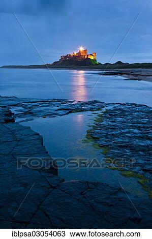 Stock Image - "Bamburgh Castle illuminated at dusk, Bamburgh, Northumberland, England, United Kingdom, Europe". Fotosearch