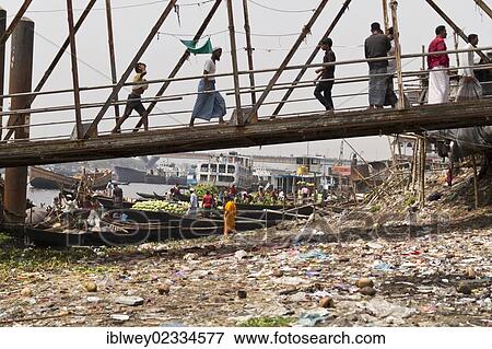 "Bank of the Buriganga River, rubbish-filled shore, pedestrians crossing over a bridge to the ferry terminal, Dhaka, Bangladesh, South Asia, Asia" View Large Photo Image Stock Photo - "Bank of the Buriganga River, rubbish-filled shore, pedestrians crossing over a bridge to the ferry terminal, Dhaka, Bangladesh, South Asia, Asia". Fotosearch