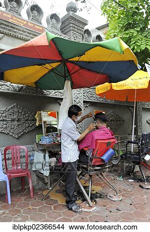 Picture - "Barber cutting hair in an outdoor salon, Phnom Penh, Cambodia, Asia". Fotosearch