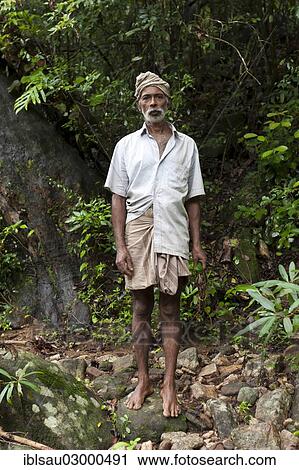 Stock Image - "Barefoot villager standing in the jungle, Knuckles Range, Knochelberge, Meemure, Sri Lanka, Asia". Fotosearch