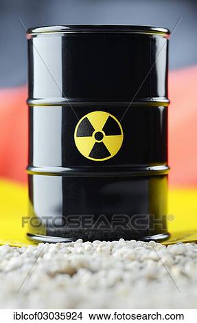 Picture - "Barrel of nuclear waste in front of a German flag, Germany, Europe". Fotosearch