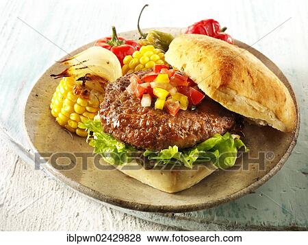 BBQ beef burger in a ciabatta roll with salsa and BBQ vegetables on a rustic plate View Large Photo Image Stock Photo - BBQ beef burger in a ciabatta roll with salsa and BBQ vegetables on a rustic plate. Fotosearch