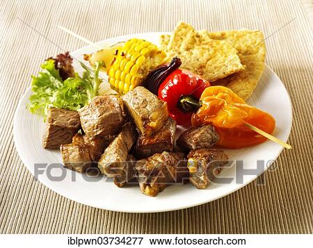 Stock Photo - "BBQ beef kebabs, sweet corn, peppers and red onions". Fotosearch