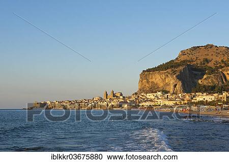 Stock Image - "Beach and the historic town centre of Cefalu in the evening light, Cefalu, Province of Palermo, Sicily, Italy, Europe". Fotosearch