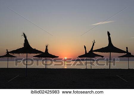 Stock Image - "Beach umbrellas at the beach at sunrise, Black Sea, Bulgaria, Europe". Fotosearch