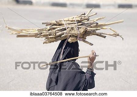 Stock Photo - "Bedouin woman carrying sugarcane on her head, Luxor, Luxor Governorate, Egypt, Africa". Fotosearch
