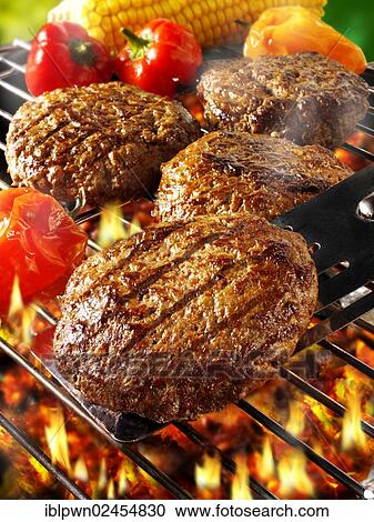 Stock Image - Beef burgers on a BBQ grill. Fotosearch