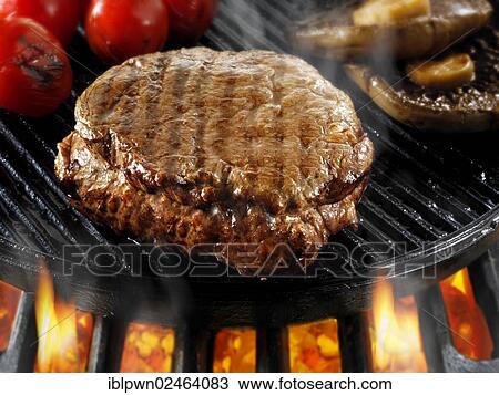 Stock Image - Beef fillet steaks and mushrooms being pan fried on a BBQ. Fotosearch