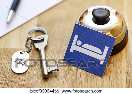 Stock Photography - "Bell and room key at a reception desk, pictogram of a bed, symbolic image for bed tax". Fotosearch
