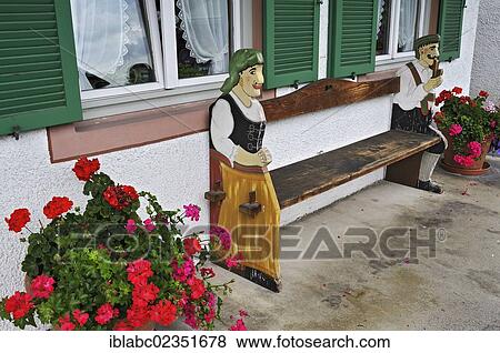 "Bench with wooden figures and Geraniums (Pelargonium), Fruehlingstrasse, Garmisch-Partenkirchen, Bavaria, Germany, Europe" View Large Photo Image Stock Photo - "Bench with wooden figures and Geraniums (Pelargonium), Fruehlingstrasse, Garmisch-Partenkirchen, Bavaria, Germany, Europe". Fotosearch