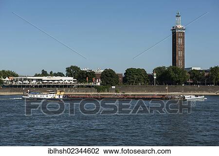 "Benny, an inland vessel traveling up the Rhine river, Tanzbrunnen venue and the historic Messeturm tower at the back, Cologne, North Rhine-Westphalia, Germany, Europe" View Large Photo Image Stock Image - "Benny, an inland vessel traveling up the Rhine river, Tanzbrunnen venue and the historic Messeturm tower at the back, Cologne, North Rhine-Westphalia, Germany, Europe". Fotosearch