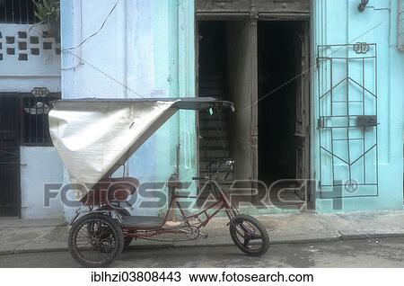 Stock Image - "Bicycle rickshaw parked in front of the entrance of a building, Havana, La Habana Province, Cuba, North America". Fotosearch