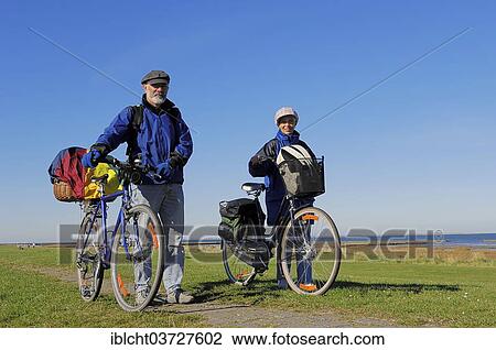 Stock Image - "Bicyclists on a dyke, Dornumersiel, East Frisia, Lower Saxony, Germany, Europe". Fotosearch
