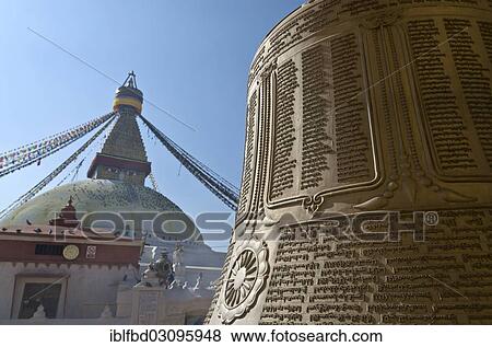 Stock Photo - "Big bell with Tibetan inscription, Boudnath Stupa at back, Kathmandu Valley, Kathmandu, Kathmandu District, Bagmati Zone, Nepal, Asia". Fotosearch