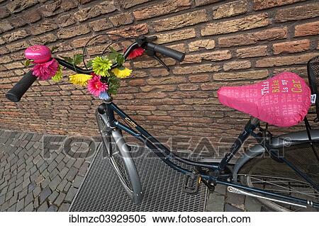 "Bike decorated with flowers leaning against a wall, Munster, Munsterland, North Rhine-Westphalia, Germany, Europe" View Large Photo Image Stock Photography - "Bike decorated with flowers leaning against a wall, Munster, Munsterland, North Rhine-Westphalia, Germany, Europe". Fotosearch