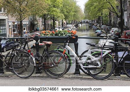 Stock Image - "Bikes on a bridge over canal, Jordaan, Amsterdam, province of North Holland, The Netherlands, Europe". Fotosearch