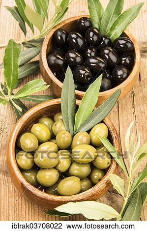 Stock Image - "Black and green olives in two wooden bowls, Germany, Europe". Fotosearch