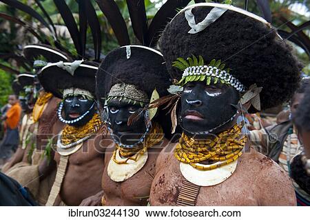 Stock Image - "Black decorated and painted tribesmen celebrating the traditional Sing Sing in the highlands, Enga, Highlands, Papua New Guinea, Oceania". Fotosearch