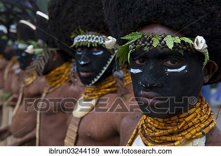 Stock Photo - "Black decorated and painted tribesmen celebrating the traditional Sing Sing in the highlands, Enga, Highlands, Papua New Guinea, Oceania". Fotosearch