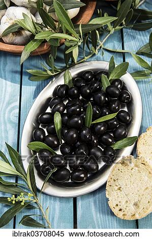 "Black olives on a platter with garlic, and olive branches, Germany, Europe" View Large Photo Image Stock Photography - "Black olives on a platter with garlic, and olive branches, Germany, Europe". Fotosearch