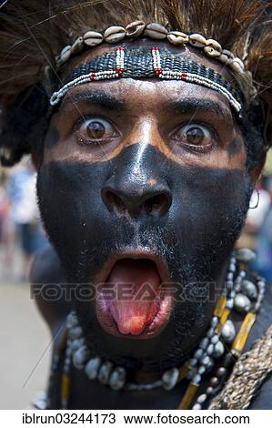 Stock Image - "Black painted and decorated man during the traditional Sing Sing in the highlands, Enga, Highlands, Papua New Guinea, Oceania". Fotosearch