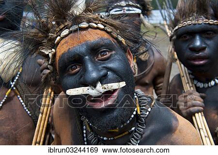 Stock Photo - "Black painted and decorated man during the traditional Sing Sing in the highlands, Enga, Highlands, Papua New Guinea, Oceania". Fotosearch