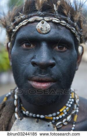 Stock Photography - "Black painted and decorated man during the traditional Sing Sing in the highlands, Enga, Highlands, Papua New Guinea, Oceania". Fotosearch