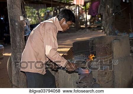 Stock Photo - "Blacksmith forging red-hot iron in a forge, Battambang, Cambodia, Asia". Fotosearch