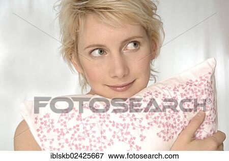 Stock Photo - Blonde woman hugging a pillow. Fotosearch