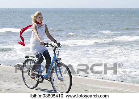 "Blonde woman in summer dress riding a bicycle by the sea, Lower Saxony, Germany, Europe" View Large Photo Image Stock Image - "Blonde woman in summer dress riding a bicycle by the sea, Lower Saxony, Germany, Europe". Fotosearch
