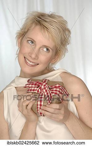 "Blonde woman is happy, holding present in her hands" View Large Photo Image Stock Image - "Blonde woman is happy, holding present in her hands". Fotosearch