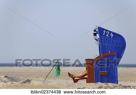 Stock Photo - "Blue roofed wicker beach chair, legs, North Sea, Amrum, Schleswig-Holstein, Germany, Europe". Fotosearch
