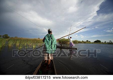 Stock Photography - "Boatman with a typical pole on a traditional mokoro boat, Okavango Delta, Botswana, Africa". Fotosearch