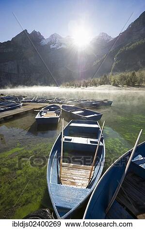 Stock Photo - "Boats and morning fog, Oeschinensee lake, Kandersteg, Bernese Oberland, Canton of Bern, Switzerland, Europe". Fotosearch