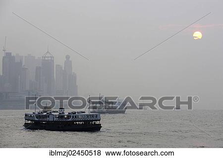 Stock Photo - "Boats in the bay of Victoria Harbour and Hong Kong Island in the evening, Hong Kong, China, Asia". Fotosearch
