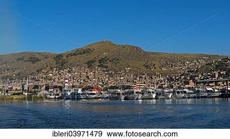 "Boats in the harbour of Puno on Lake Titicaca, city of Puno at the back, Puno, Peru, South America" View Large Photo Image Stock Photo - "Boats in the harbour of Puno on Lake Titicaca, city of Puno at the back, Puno, Peru, South America". Fotosearch