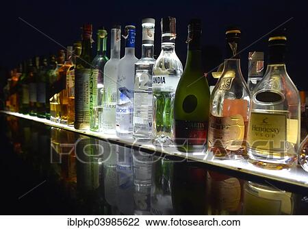 "Bottles of various spirits in a row, reflected on a glass plate" View Large Photo Image Stock Image - "Bottles of various spirits in a row, reflected on a glass plate". Fotosearch