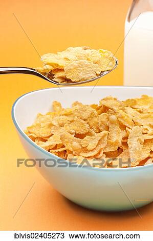 Bowl filled with corn flakes next to a milk bottle View Large Photo Image Stock Image - Bowl filled with corn flakes next to a milk bottle. Fotosearch