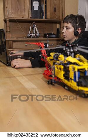 "Boy, 12 years, chattingon a laptop with headphones, in front a Lego construction set, Germany, Europe" View Large Photo Image Stock Image - "Boy, 12 years, chattingon a laptop with headphones, in front a Lego construction set, Germany, Europe". Fotosearch