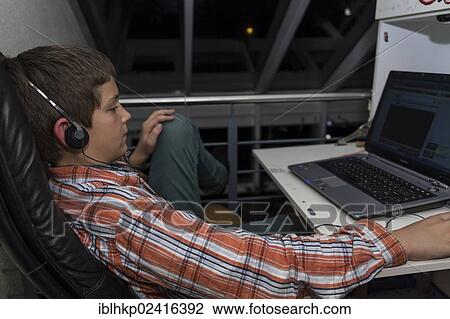 Boy, 12 years old, listening to music from the internet on a laptop View Large Photo Image Stock Image - Boy, 12 years old, listening to music from the internet on a laptop. Fotosearch