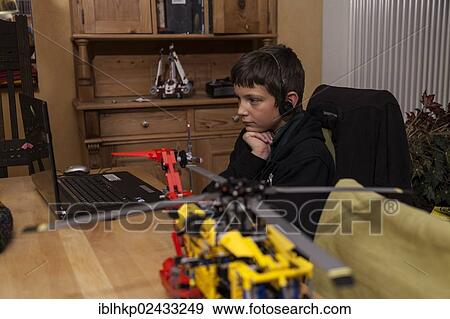 "Boy, 12 years, watching video on a laptop with headphones, in front a Lego construction set, Germany, Europe" View Large Photo Image Stock Photo - "Boy, 12 years, watching video on a laptop with headphones, in front a Lego construction set, Germany, Europe". Fotosearch