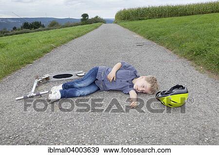 "Boy, 5 years, lying on a road after a scooter accident" View Large Photo Image Stock Photo - "Boy, 5 years, lying on a road after a scooter accident". Fotosearch