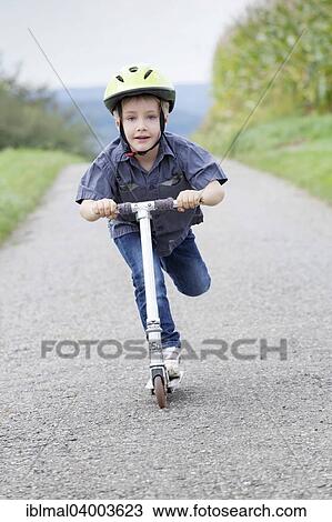 "Boy, 5 years, on a scooter wearing a helmet" View Large Photo Image Stock Image - "Boy, 5 years, on a scooter wearing a helmet". Fotosearch
