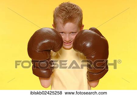 Stock Photo - "Boy, 6, wearing oversized boxing gloves". Fotosearch