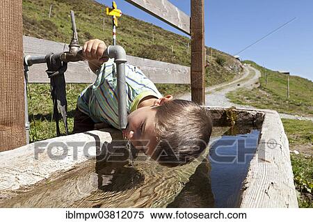 "Boy, 6 years, drinking fresh spring water from the well, Alp Gun, Safien Valley, Graubunden, Switzerland, Europe" View Large Photo Image Stock Photography - "Boy, 6 years, drinking fresh spring water from the well, Alp Gun, Safien Valley, Graubunden, Switzerland, Europe". Fotosearch