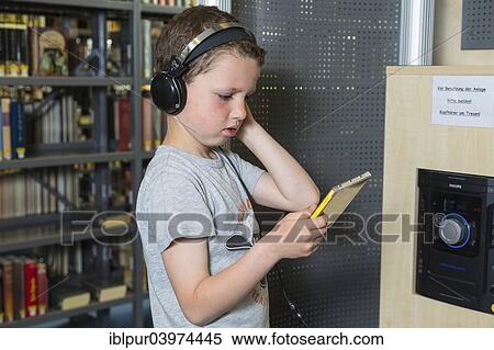 "Boy, 7 years, listening to a CD with headphones, public library, Coswig, Saxony, Germany, Europe" View Large Photo Image Stock Photography - "Boy, 7 years, listening to a CD with headphones, public library, Coswig, Saxony, Germany, Europe". Fotosearch